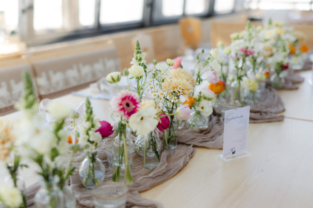 Liebevoll gedeckter Hochzeitstisch auf der Hohe Mut Alm mit Blick auf die Berglandschaft – Weddings by Cara