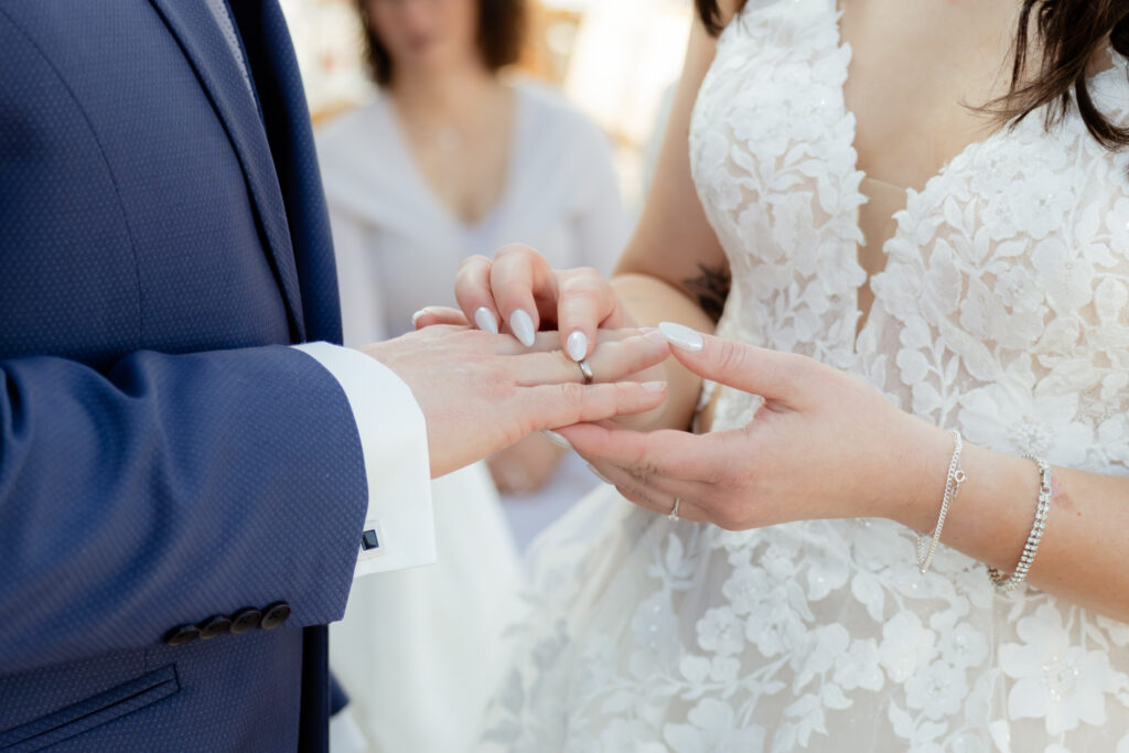 Brautpaar bei der Trauung auf der Hohe Mut Alm in den österreichischen Alpen, die Ringe werden angesteckt