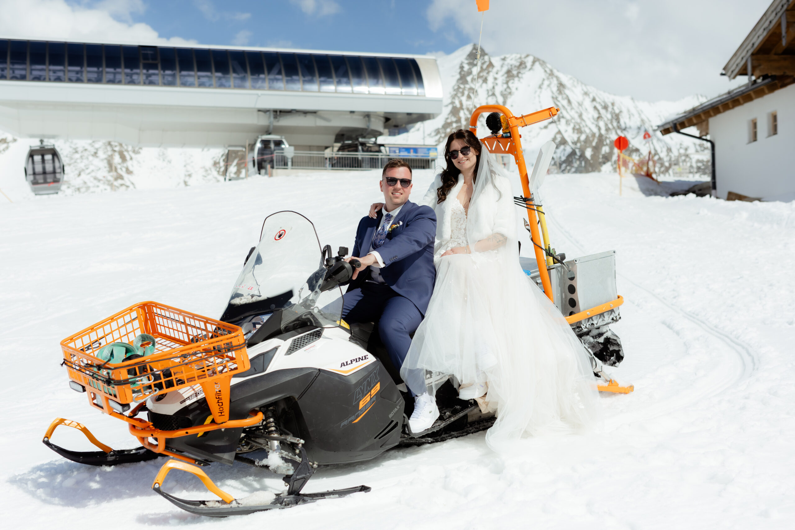 Brautpaar auf einem Snowmobil für ein einzigartiges Shooting in den Alpen – Weddings by Cara.