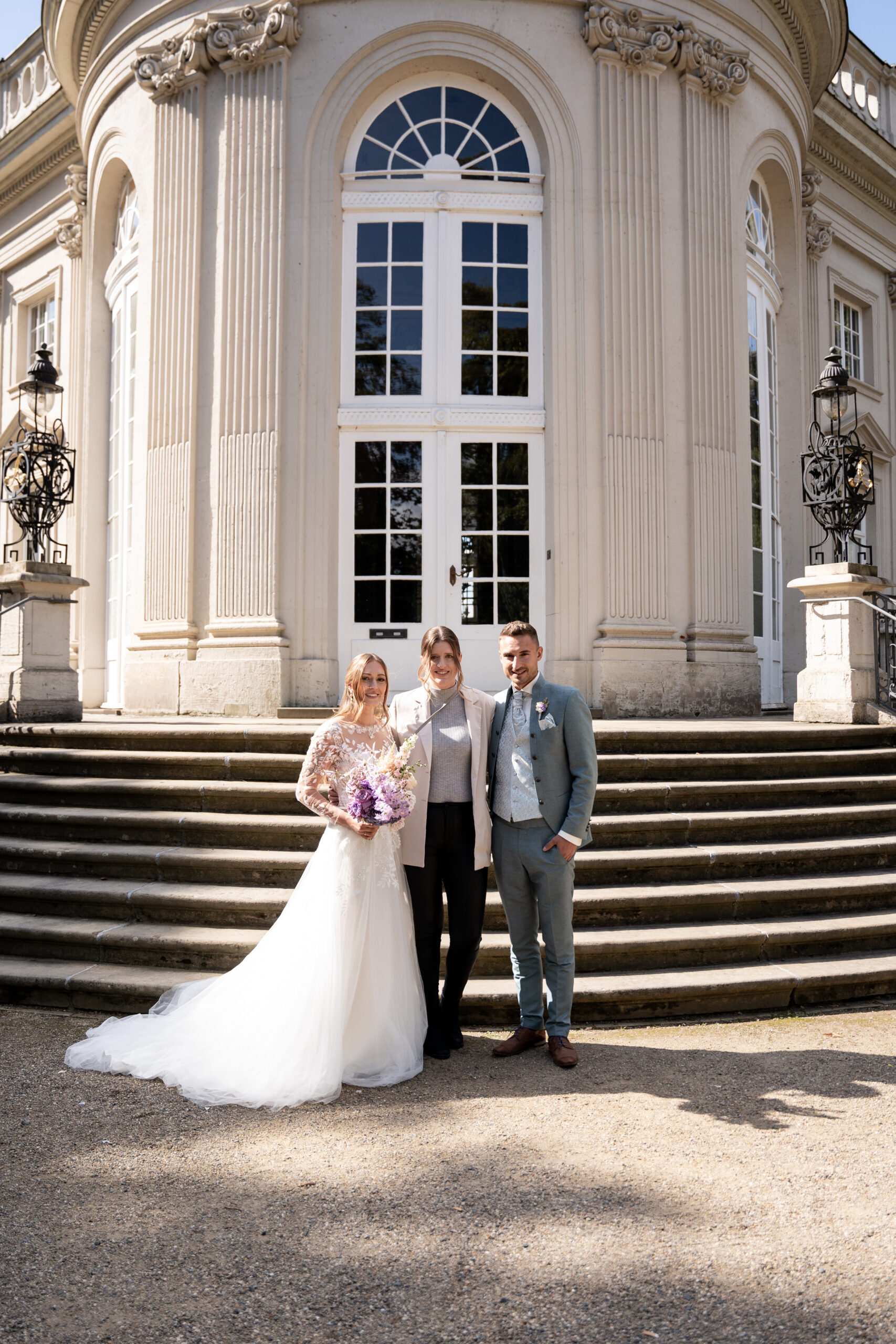 Hochzeitsplanerin mit Brautpaar am Hochzeitstag in Braunschweig vor dem Schloss Richmond